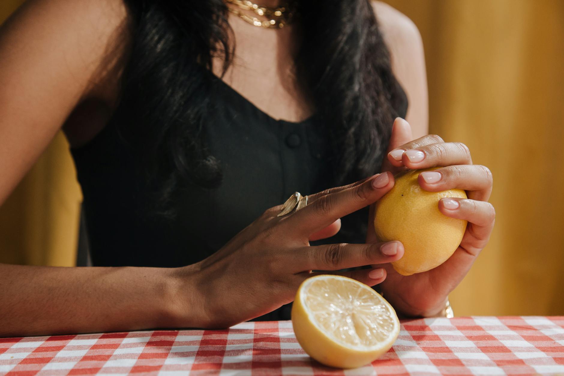 Close-up of a blue clitoral vibrator surrounded by fresh orange slices and white flowers on a bright yellow background