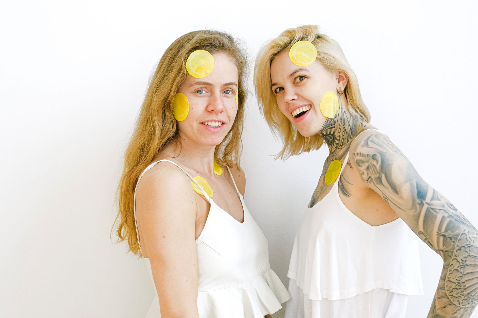 Two hands holding silicone vibrators against a soft pastel background