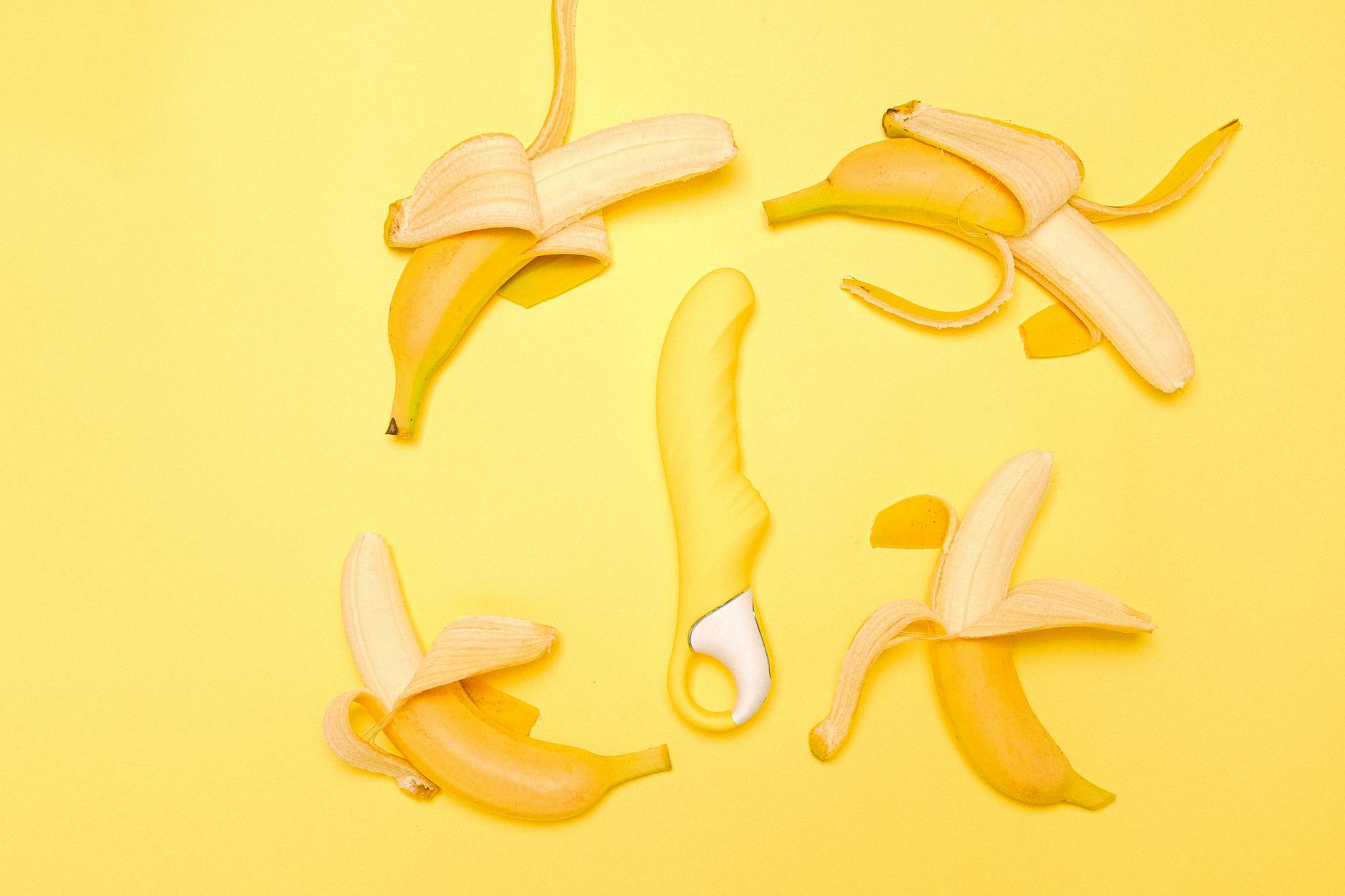 Yellow lemon vibrator on a bright yellow background with fresh lemons