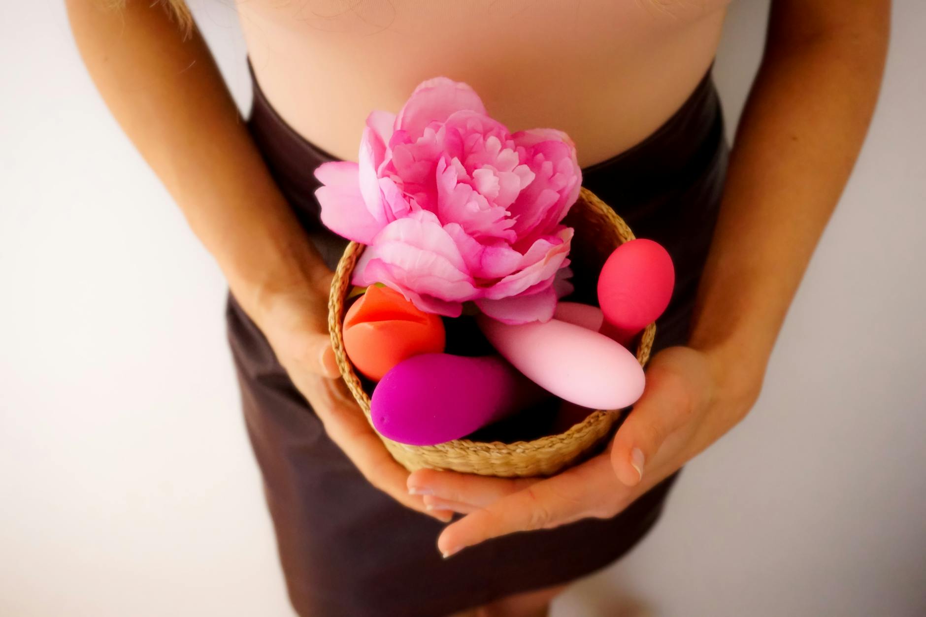 Pink clitoral vibrator on purple background with heart confetti and candles